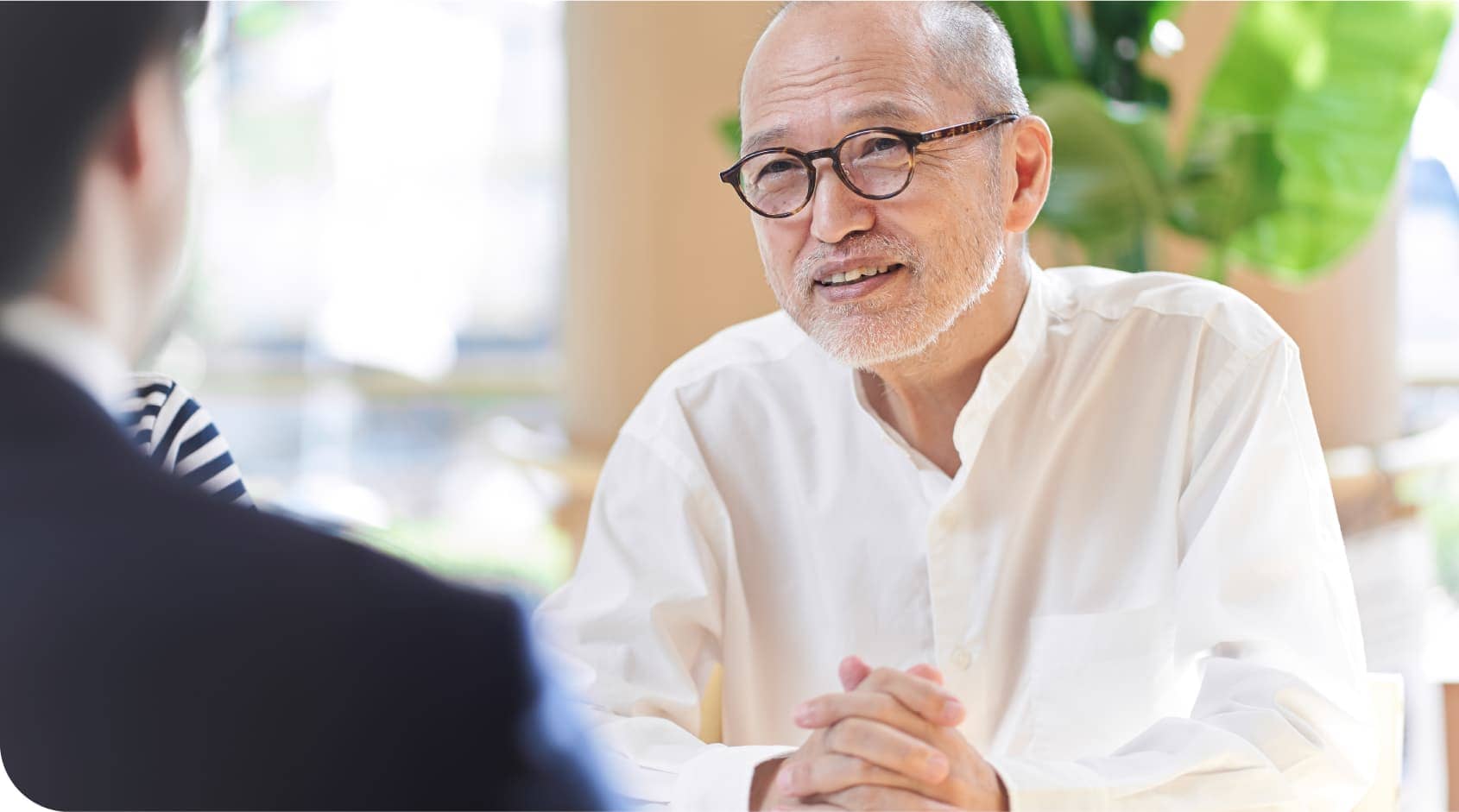 壮年の男性と会話するスーツの社員