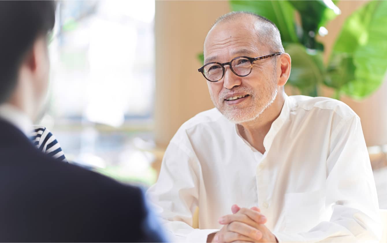 壮年の男性と会話するスーツの社員